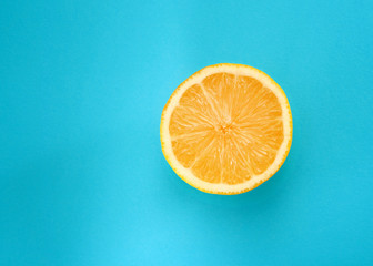 Lemon cut on blue juicy background. Isolated on blue