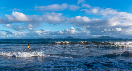 Vague sur une plage tropicale avec un enfant se baignant