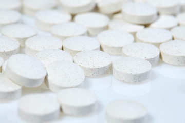White pills on white background. Close up