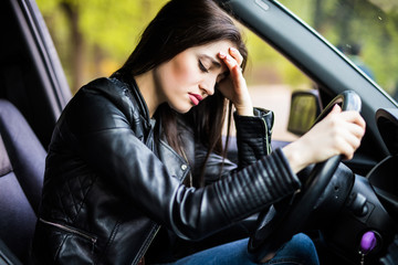 Business woman having headache taking off her glasses has to make a stop after driving car in traffic jam on rush hour. Exhausted, overworked driver concept.