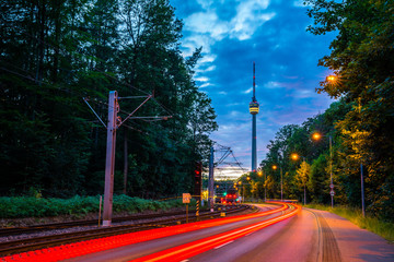 Germany, Illuminated tracer lights of cars and traffic on road to famous stuttgart television tower...