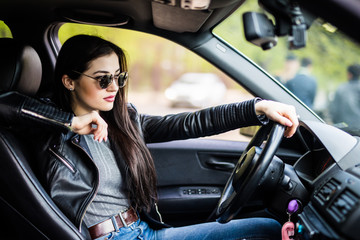 Plakat Side view of young woman driving a car