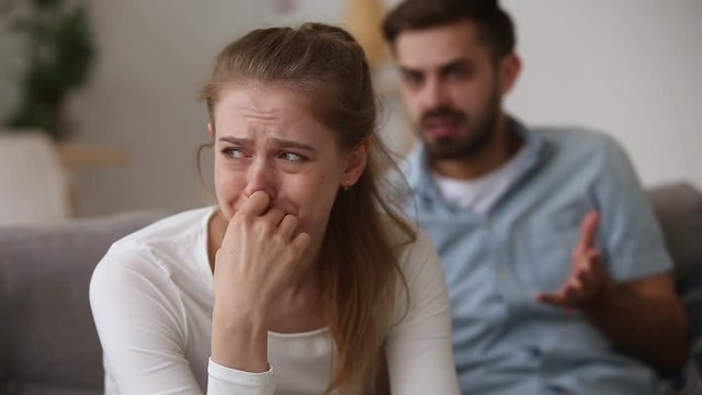 Young couple quarrelling girlfriend crying while boyfriend screaming accusing her