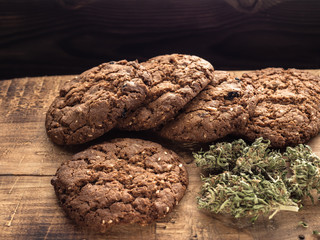 cannabis and textured cookies on a wooden board. close-up.