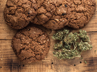 cannabis and textured cookies on a wooden board. close-up.