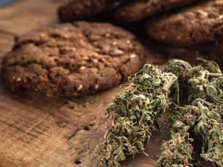 cannabis and textured cookies on a wooden board. close-up.