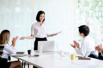 Group of business asian people hands clapping after businesswoman presenting.