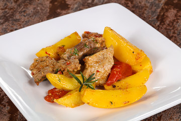 Baked pork meat with potao and tomato