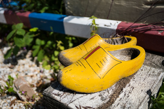 a pair of Dutch yellow painted wooden shoes on a box.