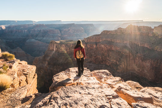 Girl Solo Hiker Traveler On The Edge Of A Cliff Watching A Beautiful View Of Grand Canyon West Rim