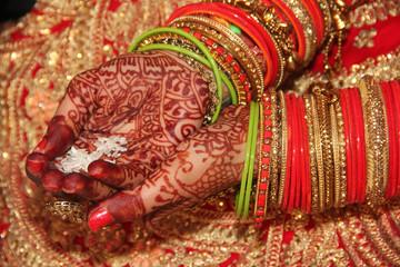 Indian bride's hands with henna design during marriage.