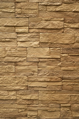Close up abstract pattern of sandstone brick wall background in vintage tone style and vertical frame,