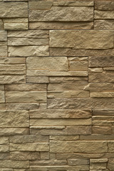 Close up abstract pattern of sandstone brick wall background in vintage tone style and vertical frame,