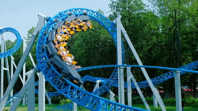 people ride upside-down circle on blue roller coaster