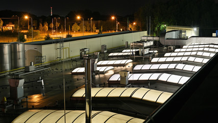 Illuminated skylights on the evening roof and air conditioning units.