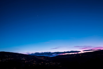 Valley with th city bellow during blue hour
