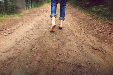 Person walking barefoot on gravel muddy road - Powered by Adobe