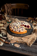 homemade tasty biscuit cake with cherries, almond flakes, powdered sugar on top