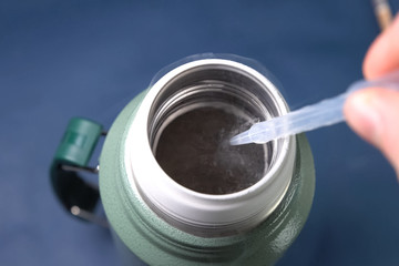 Liquid air, pouring liquefied air into thermos.