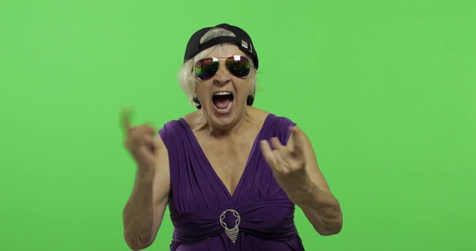 Elderly woman in sunglasses shouts with a smile and showing tongue. Chroma key