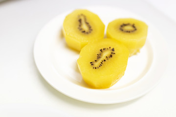 Golden kiwi fruit (Actinidia chinensis) on plate; ready to eat. Top view and copy space.