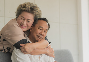 Senior Asian woman feeling sorry and make up for apologies with her husband while he is sulking