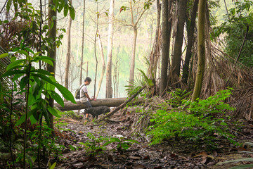 Man hiking with his dog in a tropical jungle