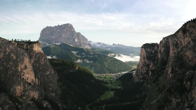 Beautiful mountain aerial view of Dolomite Alps and a small town during sunset
