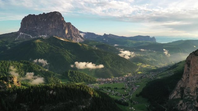 Hyperlapse aerial view of a beautiful Dolomite Alps mountains and a small town during sunset