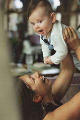 Mother lifting and playing with baby boy