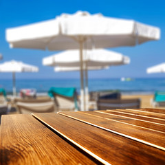 Summer background of beach and wooden desk of free space 
