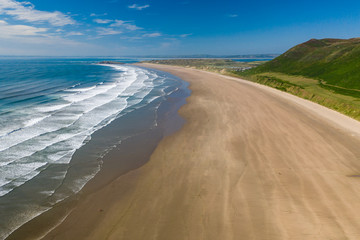 Fototapeta na wymiar Aerial drone view of the beautiful, huge sandy beach at Rhossili on the Gower Peninsula in Wales