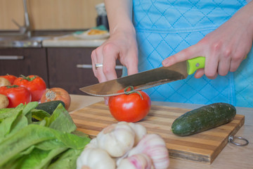 woman hands cutting vegetables on kitchen blackboard. Healthy food. Woman preparing vegetables, cooking healthy meal in the kitchen