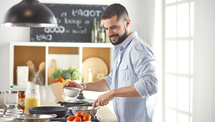 Smiling and confident chef standing in large kitchen