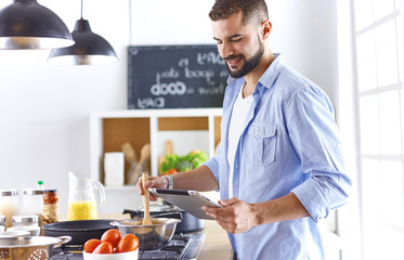 Smiling and confident chef standing in large kitchen