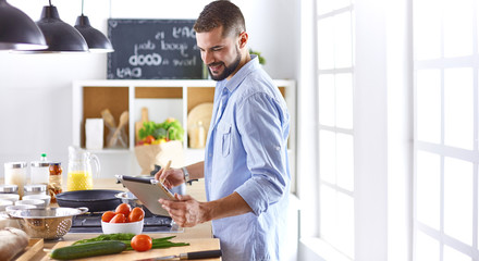 Smiling and confident chef standing in large kitchen