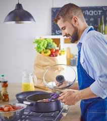 Smiling and confident chef standing in large kitchen