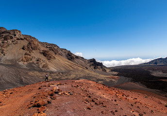 person observing landscape of crater, mountains and clouds