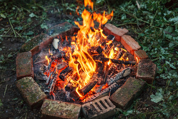 Bonfire in circle made of red bricks