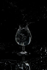 Obraz na płótnie Canvas Ice in water in a transparent glass on a dark background