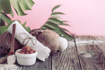 Spa and wellness setting with flowers and towels. Bright composition on pink background with tropical flowers. Dayspa nature products with coconut