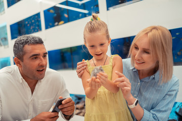 Blonde little girl feeling amazing while holding hamster