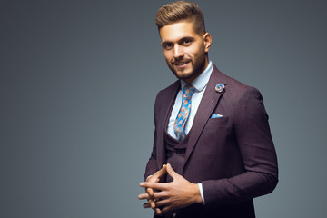 Stylish young man in suit and tie. Business style. Fashionable image. Office worker. Sexy man standing and looking at the camera