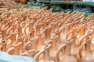 Fototapeta na wymiar Ceramic jugs are sold at a flea market in Tbilisi, Georgia. Close-up of jugs necks, many ceramic jugs