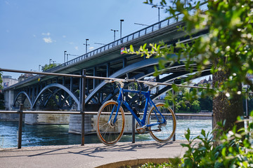 Bicycle Parked On Road By River Against Bridge In City During Sunny Day