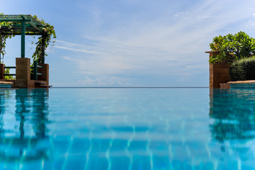 Fototapeta na wymiar Endless swimming pool with blue sky background natural landscape.