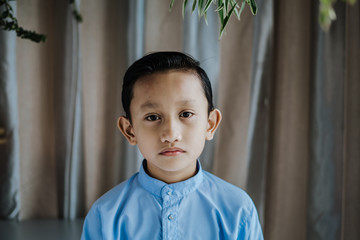 Portrait of south asian handsome little boystanding and smiles. Malaysian people.