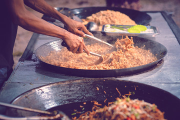 Asians man cooking streetfood. Unidentified asian people sell food at night market walk street. Asian, Indian and Chinese street food. Food court on local market of Langkawi island, Malaysia.