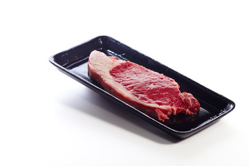 raw beef steak in  package on white