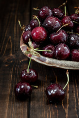 Close-up view of wet Cherry on a wooden background with water drops. Ripe cherry